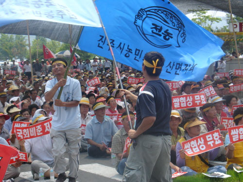 노래패 맥박의 '아스팔트 농사' 노래공연에 맞춰 농민들이 피켓과 깃발을 흔들고 있다. 